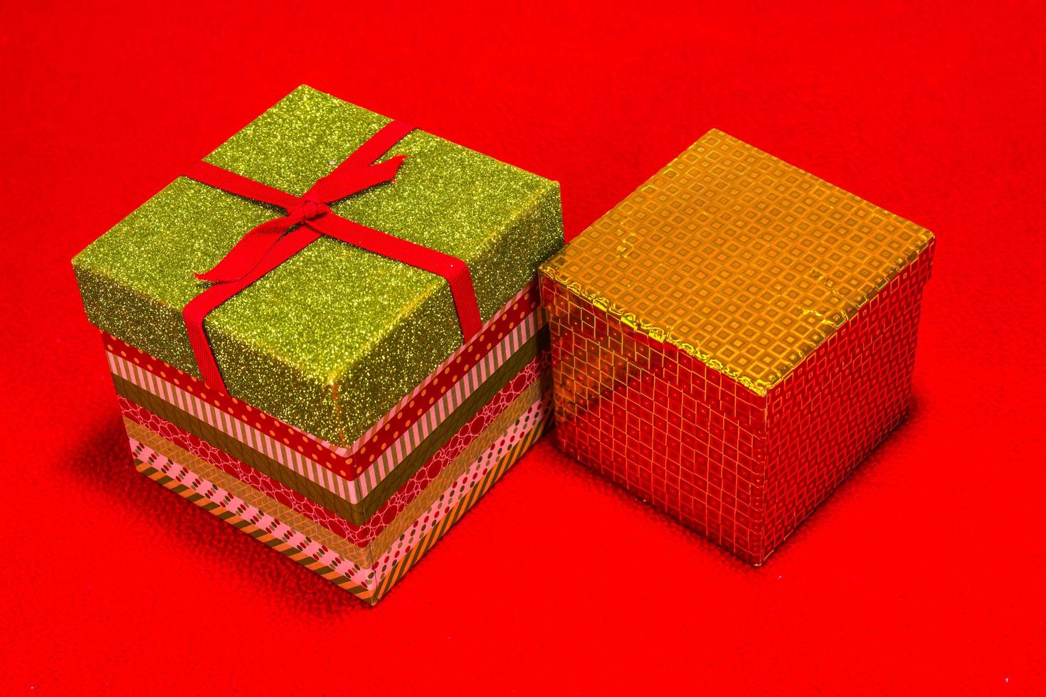 duas caixas de presente de natal em fundo vermelho foto