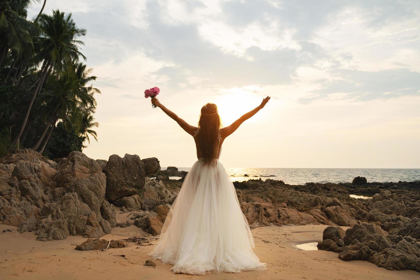 noiva usando lindo vestido de noiva na praia foto