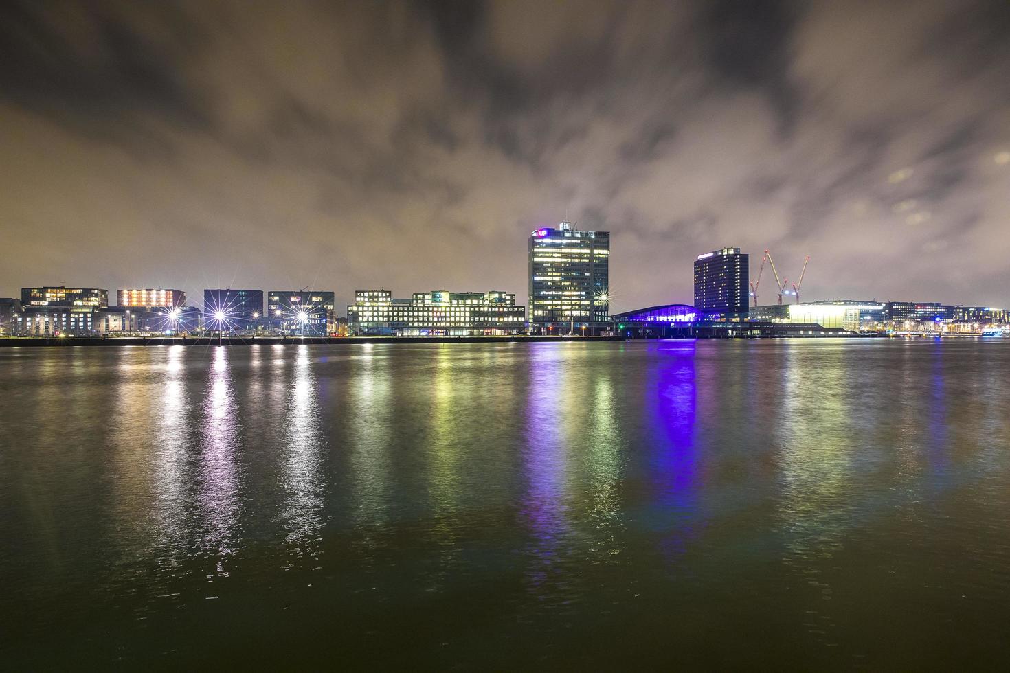 visão noturna sobre o rio da cidade com reflexo de edifícios modernos foto