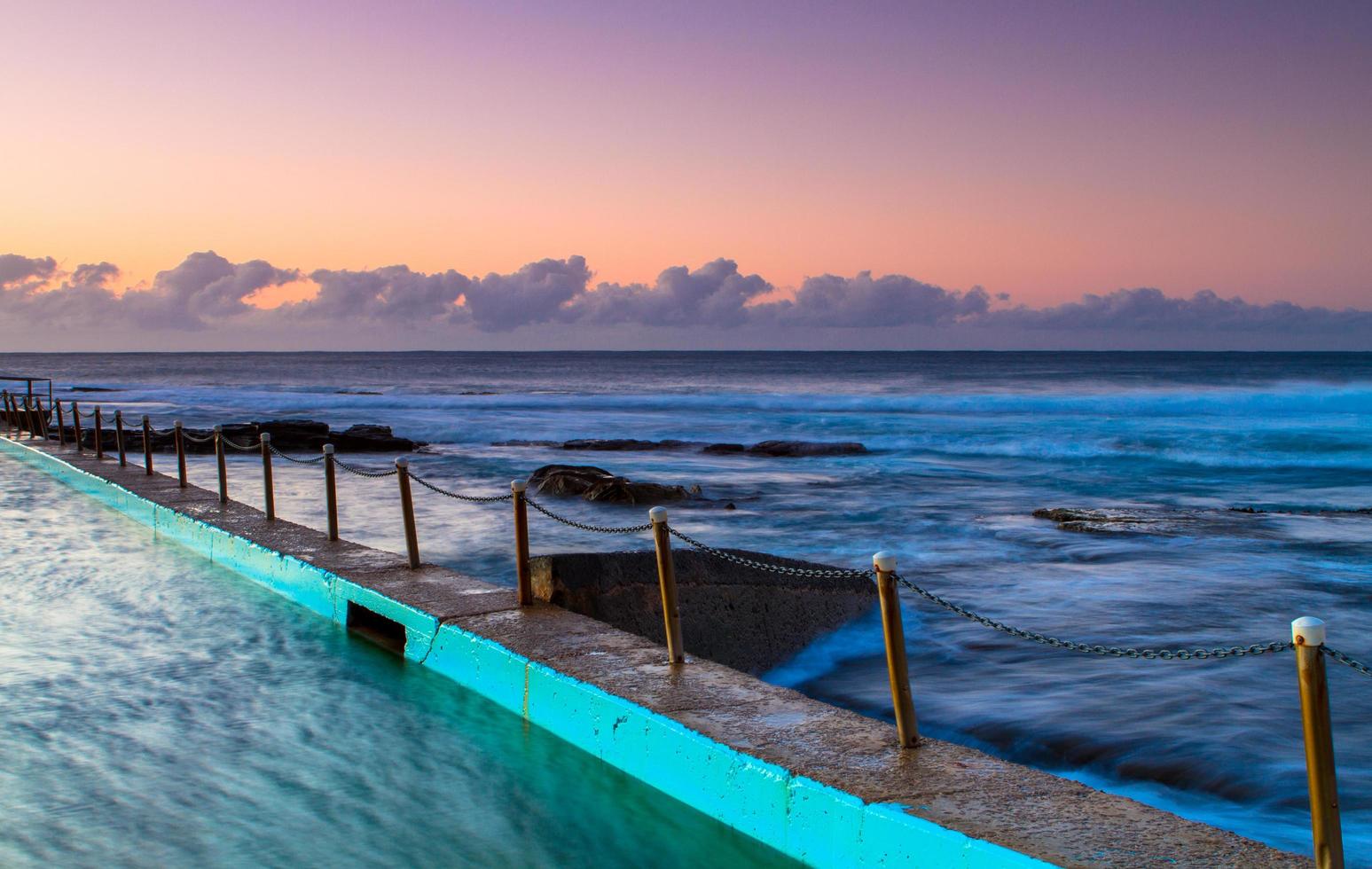 pôr do sol de uma doca à beira-mar foto