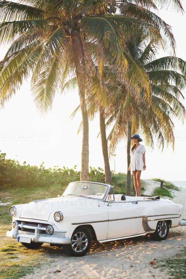 mulher jovem feliz e carro conversível retrô foto