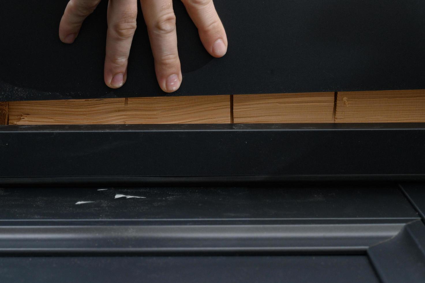 verificando a uniformidade da superfície da moldura da porta após a instalação usando uma régua de metal. foto