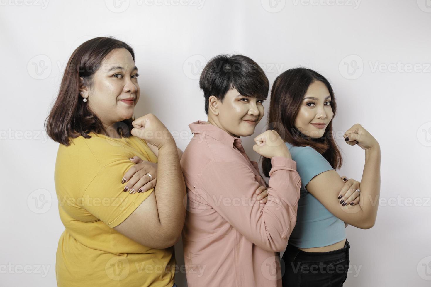 um retrato de três amigos parece animado enquanto mostra gestos fortes levantando seus braços e músculos e sorrindo com orgulho foto