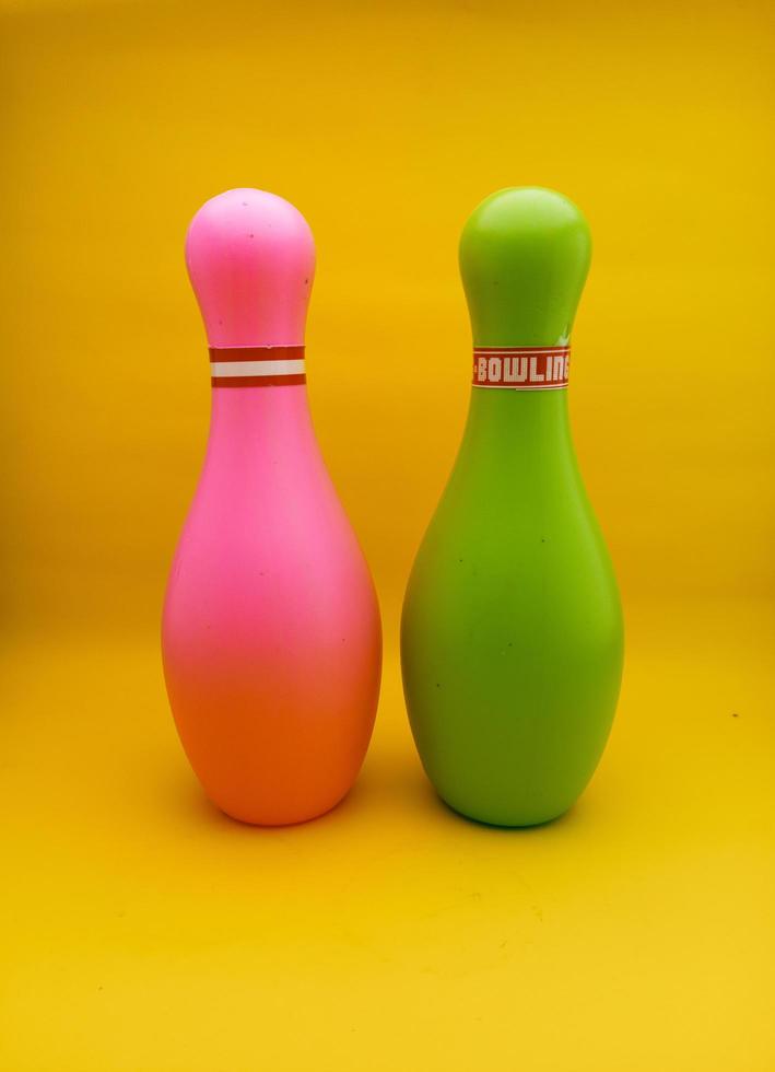 brinquedos de bola de boliche rosa e verde com fundo amarelo isolado foto