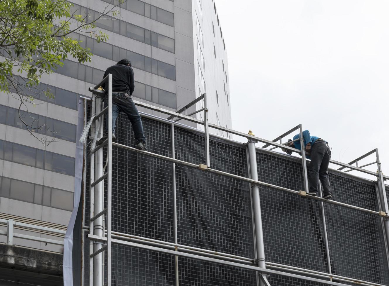 trabalhadores escalam estruturas de outdoors para instalar outdoors foto