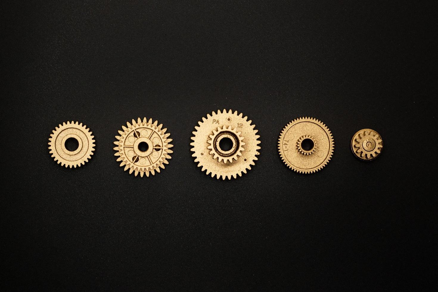 modelo de cinco engrenagens douradas em fundo preto foto
