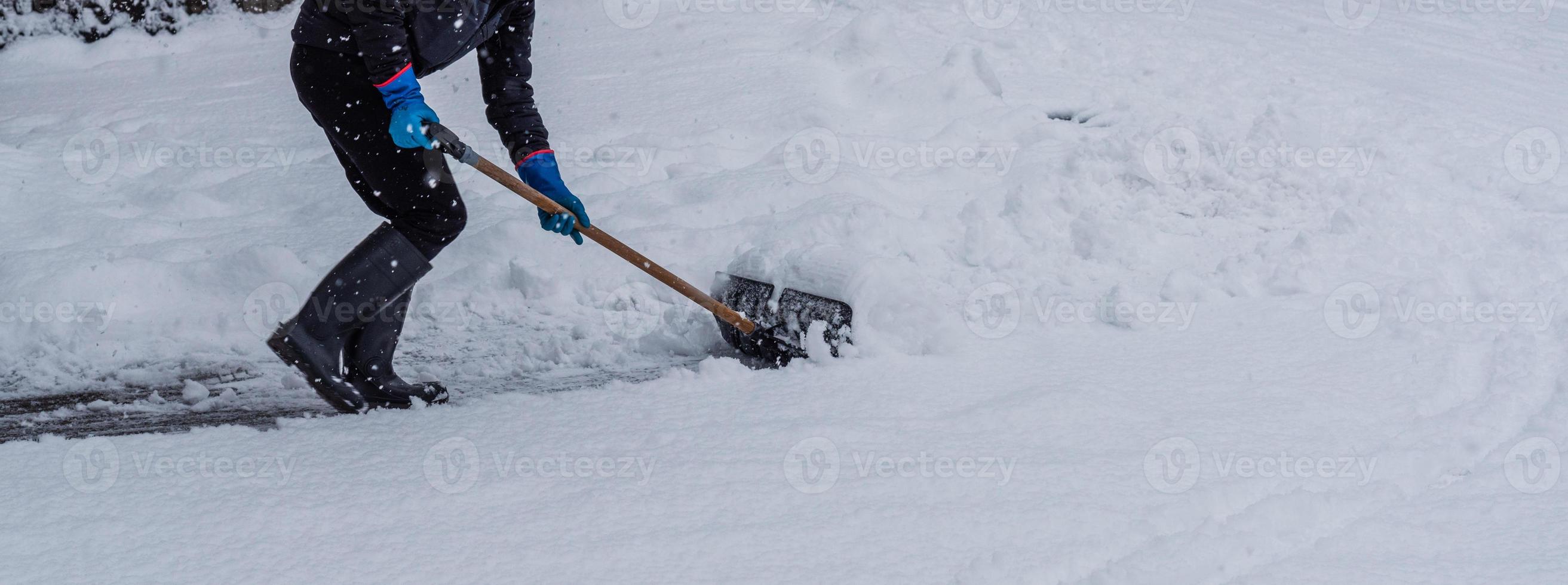 jovem removendo neve do caminho a pé no inverno. foto