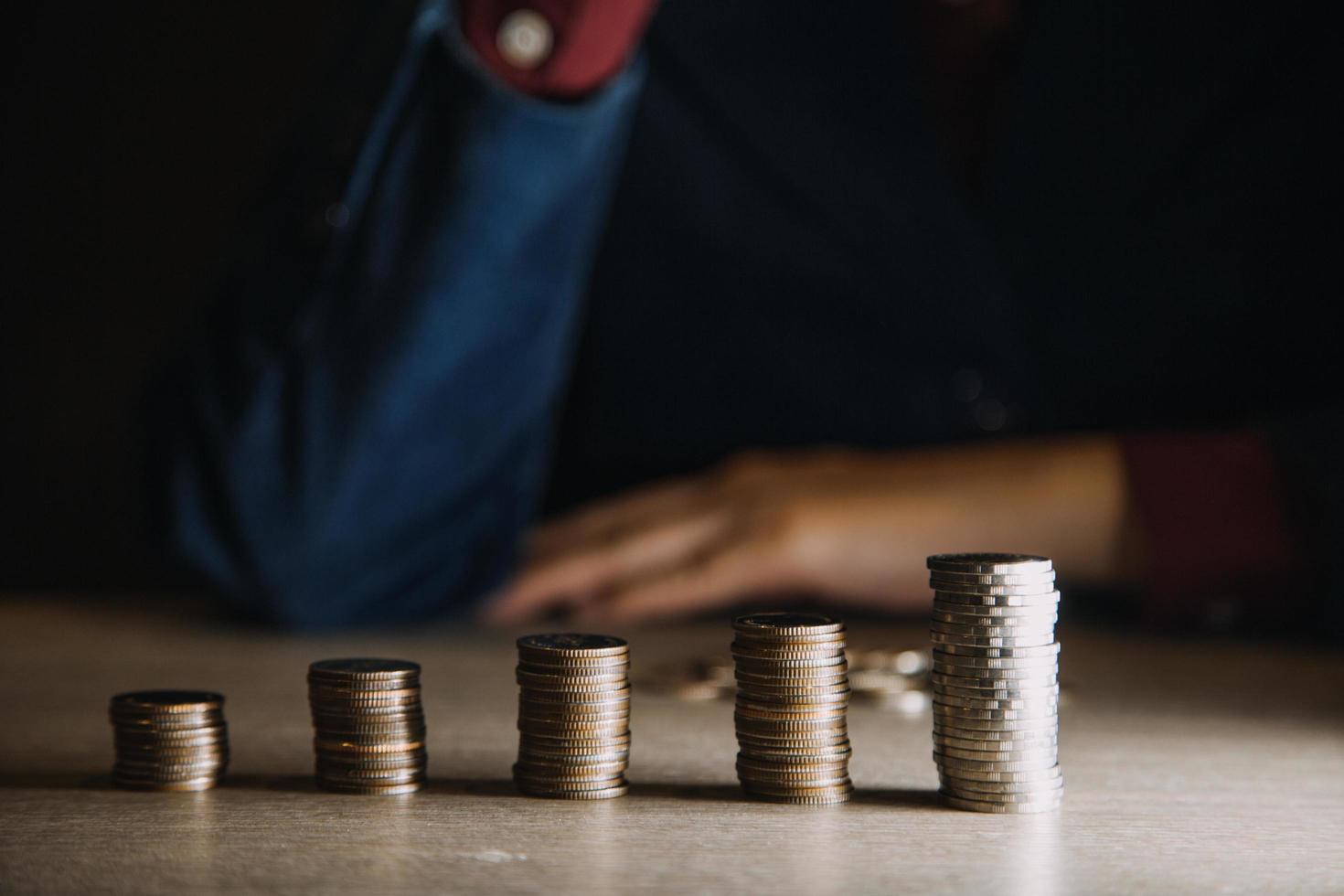 empresário segurando moedas colocando em vidro. conceito de economizar dinheiro para contabilidade financeira foto