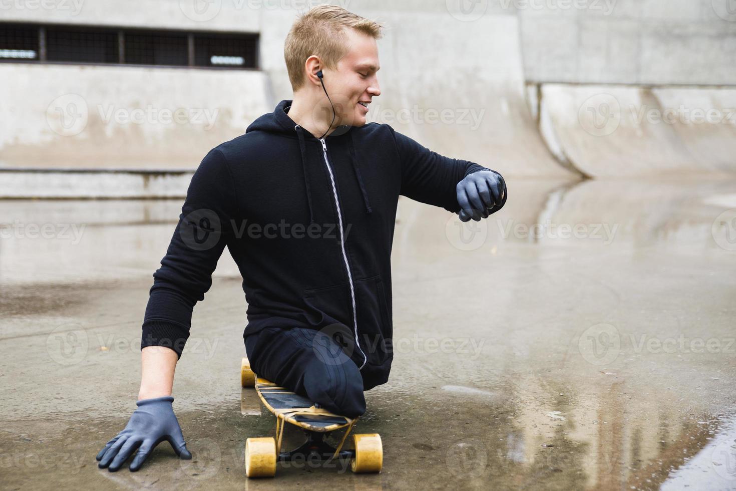 cara deficiente motivado com um longboard no skatepark foto