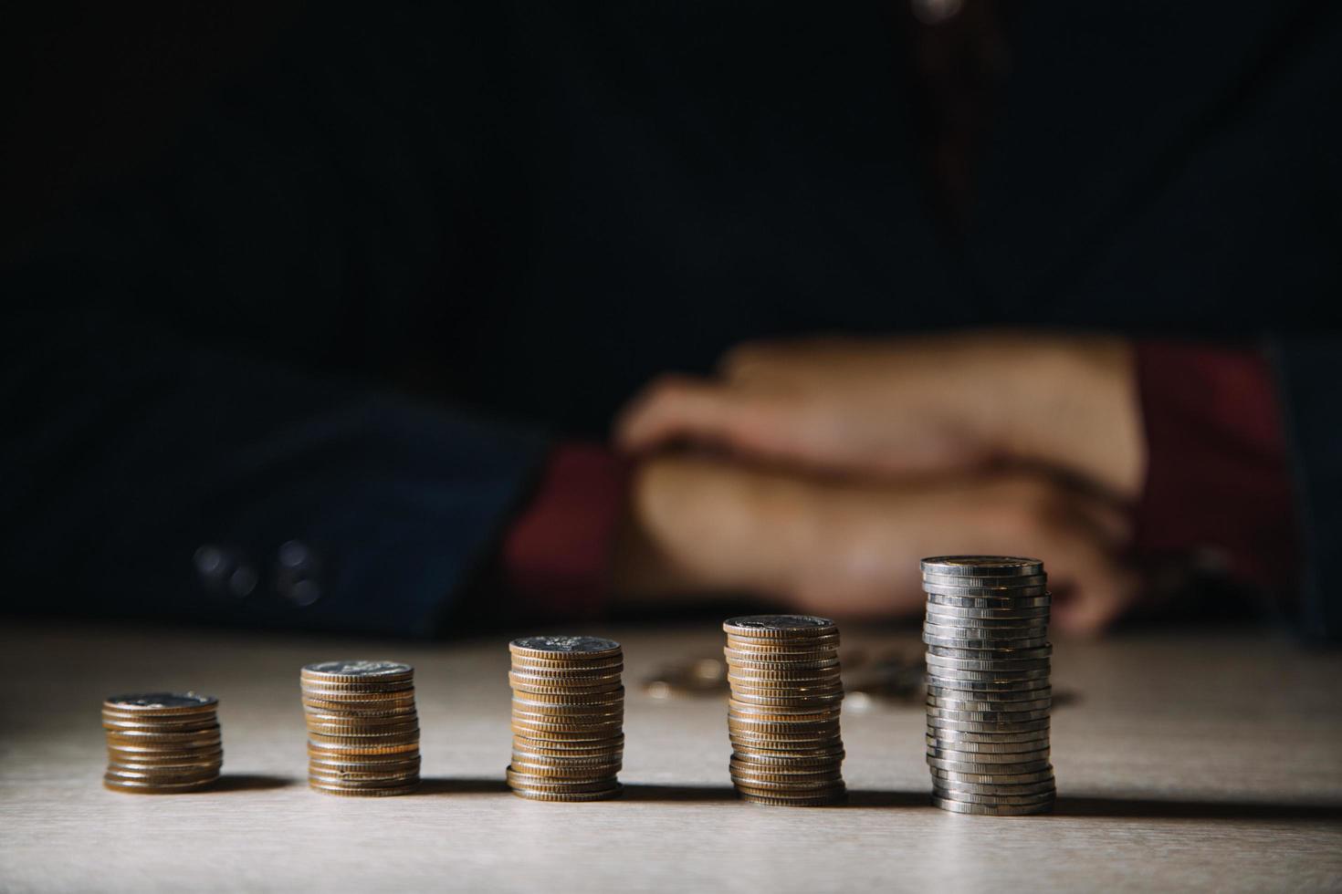 mão colocando dinheiro de moeda na pilha de moedas. investir conceito. foto