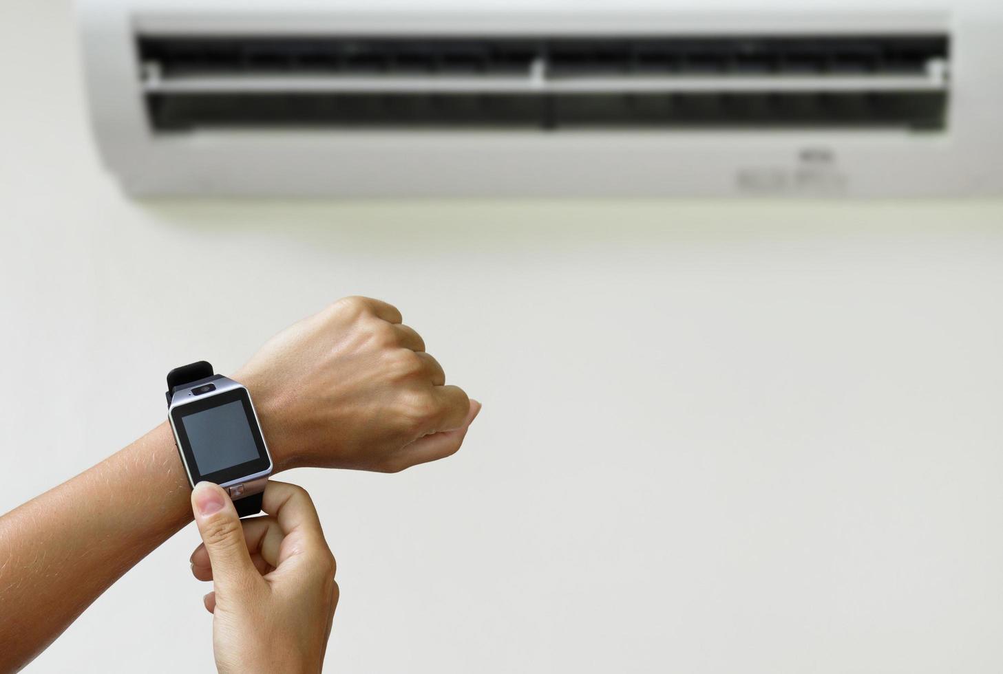 controle climático com um smartwatch. mulher usando ac. foto