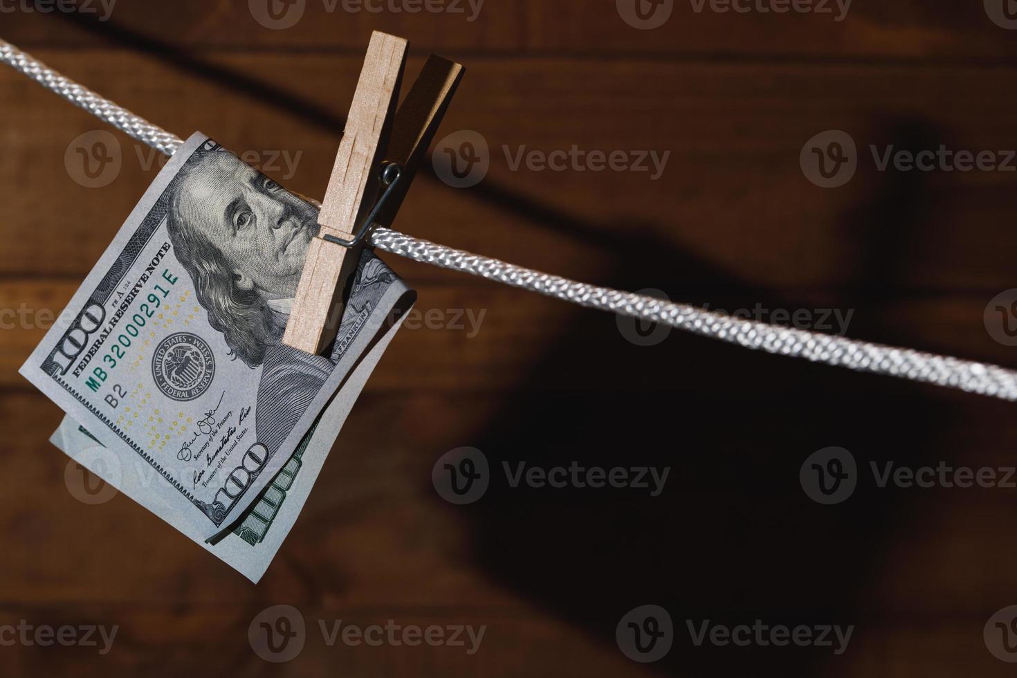Nota de dólar americano é pendurada em uma corda com prendedor de roupa. foto