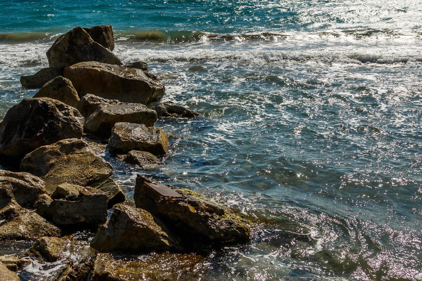 bela vista do mar com água azul e pedras foto