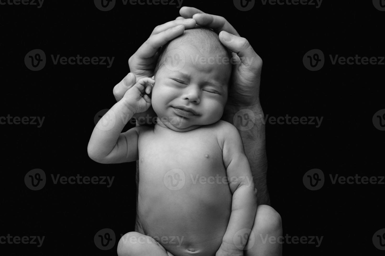 bebê recém-nascido engraçado nas mãos do pai foto