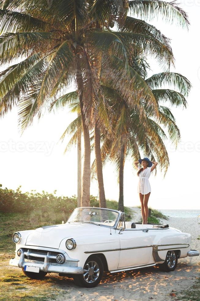 mulher jovem feliz e carro conversível retrô foto