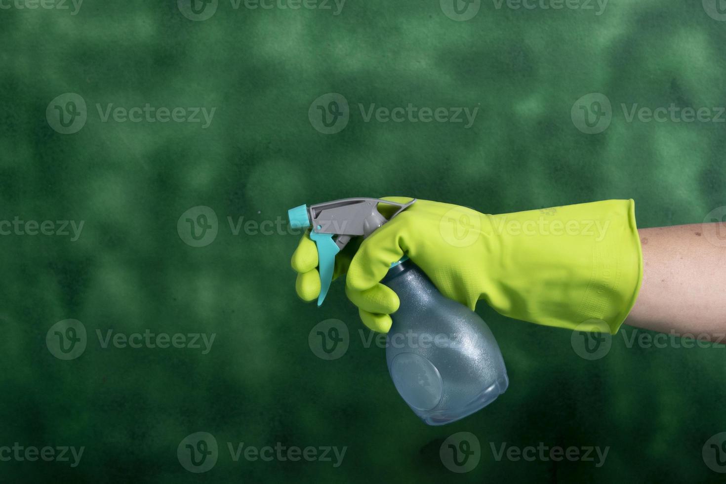mão com luva protetora segurando embalagens de produtos de limpeza usados para higiene doméstica foto