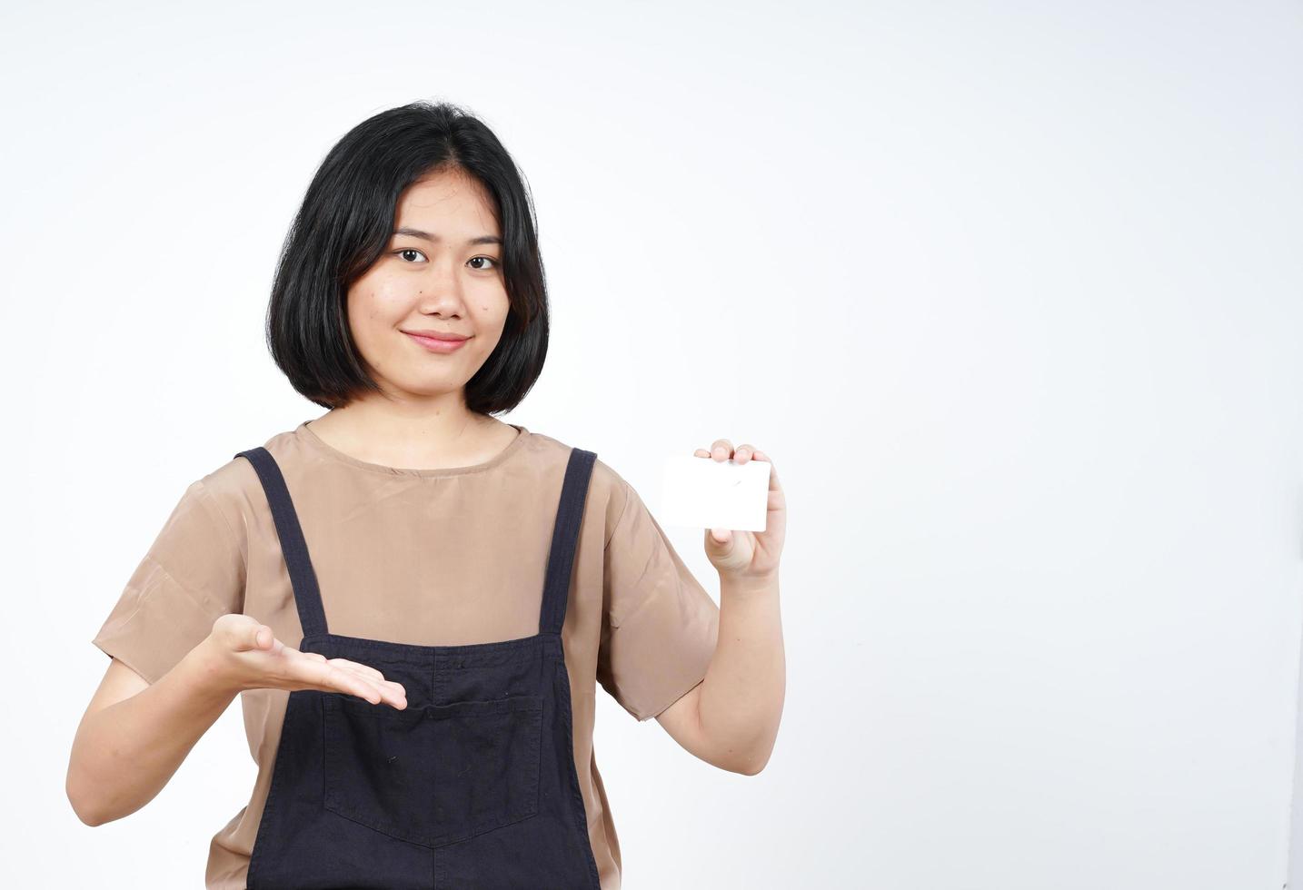 segurando e mostrando o cartão de crédito em branco da bela mulher asiática isolada no fundo branco foto