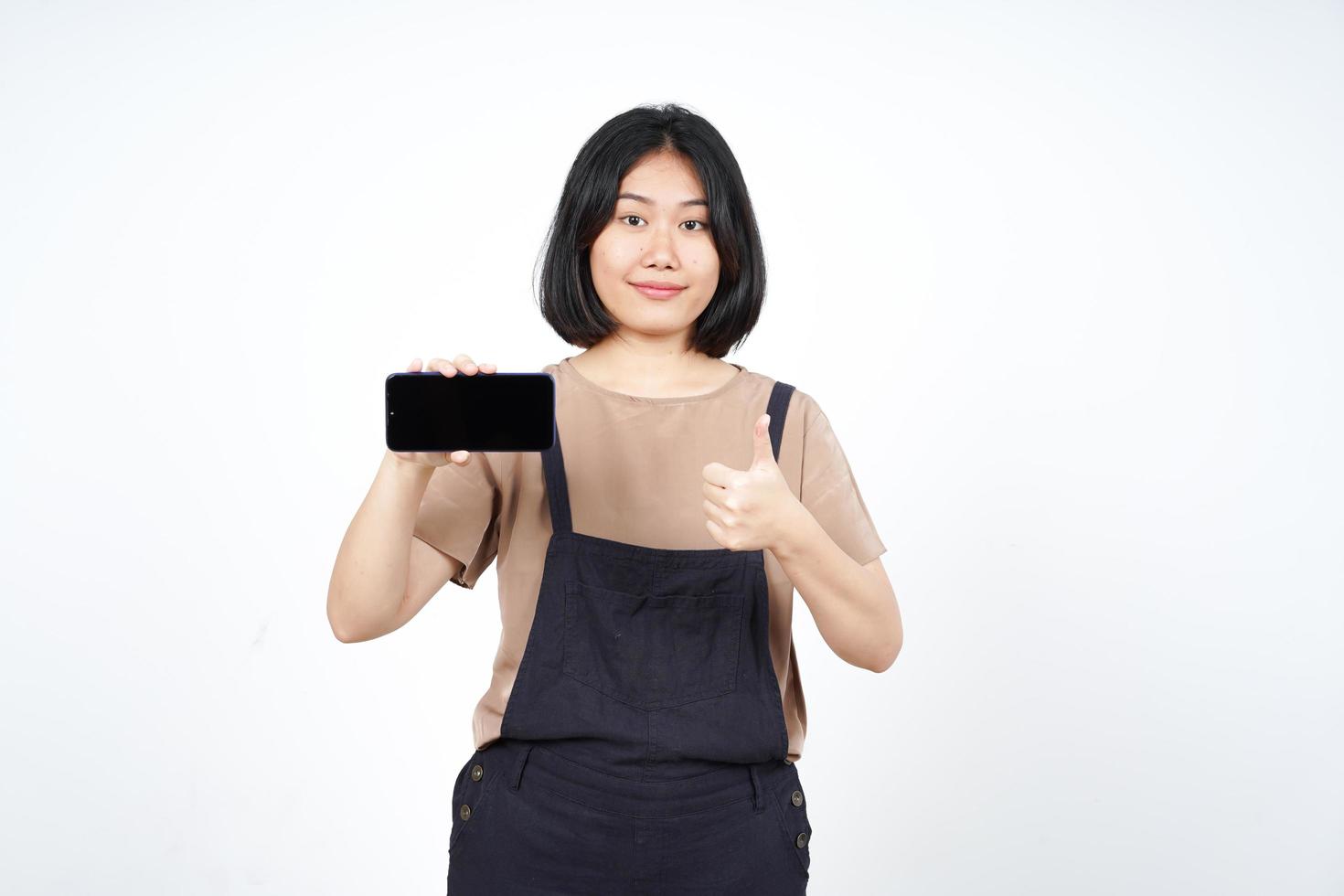 mostrando aplicativos ou anúncios no smartphone de tela em branco da bela mulher asiática isolada no fundo branco foto