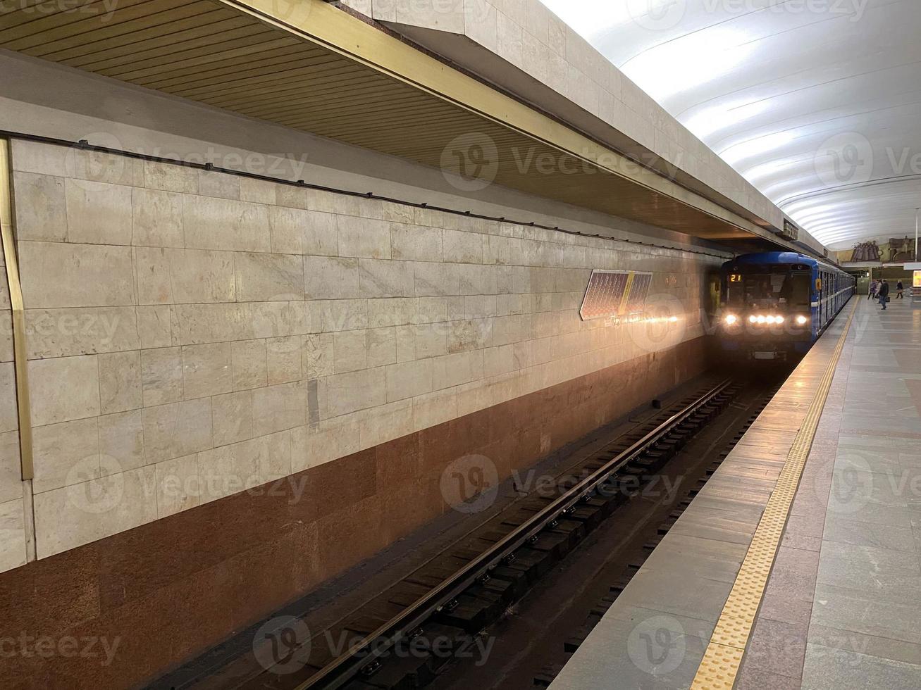 vista do túnel na plataforma de espera de trens na estação de metrô com paredes de granito foto