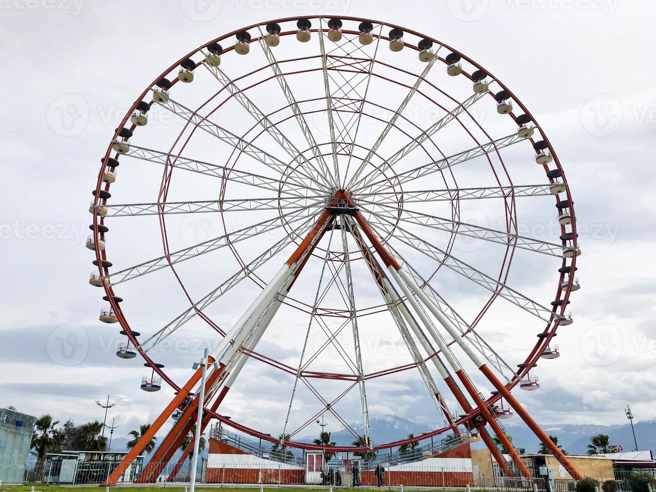 uma grande roda gigante redonda e bonita, uma plataforma panorâmica em um parque em um mar tropical resort de verão quente com palmeiras contra um céu azul foto