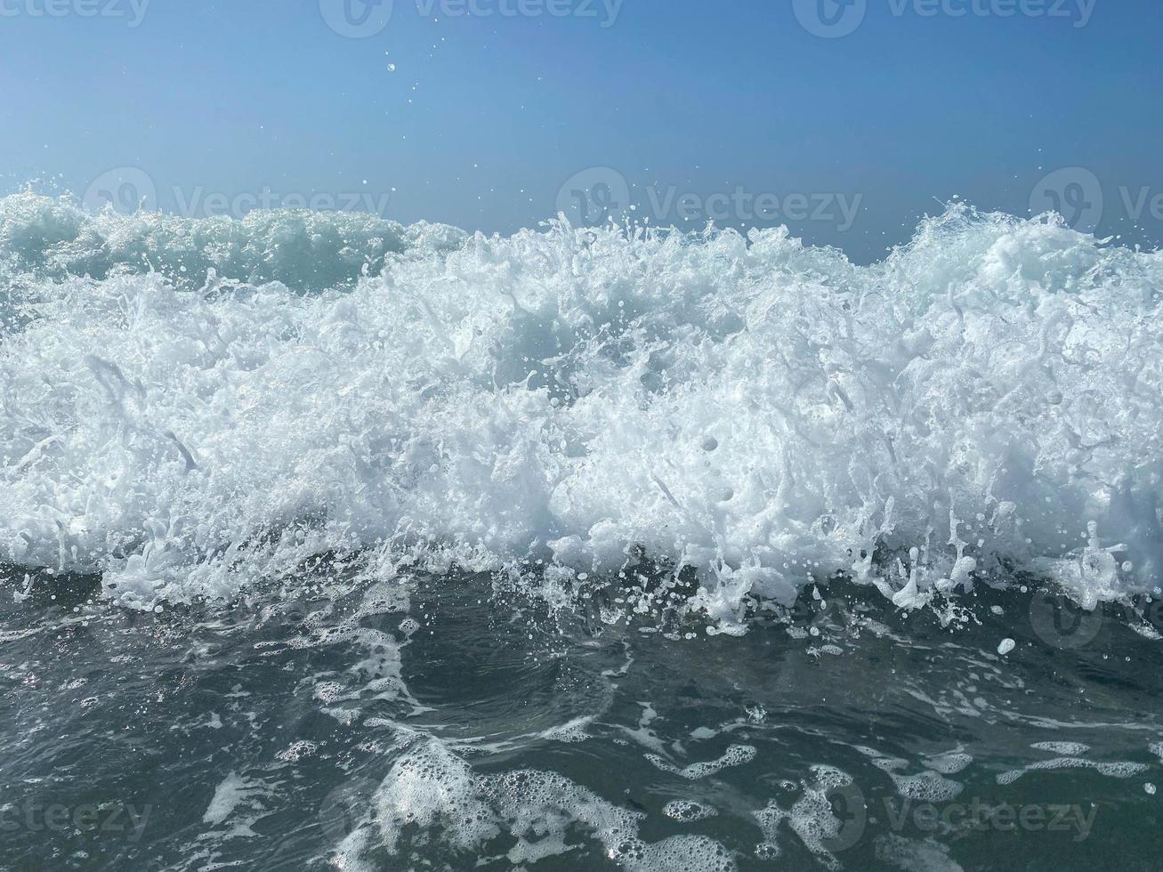 belo mar com ondas espirrando água azul clara e morna em um resort do sul do país oriental tropical quente. fundo, textura foto