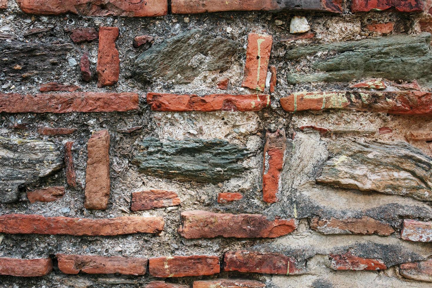 parede de pedra cinza antiga emoldurada por tijolo vermelho. alvenaria turca. foto