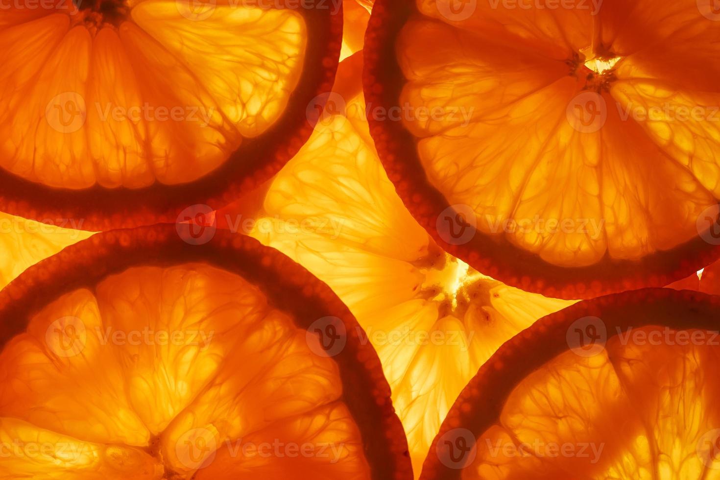fatias de polpa e raspas de laranja madura com iluminação de fundo como fundo textural, o substrato. tela cheia, close-up foto