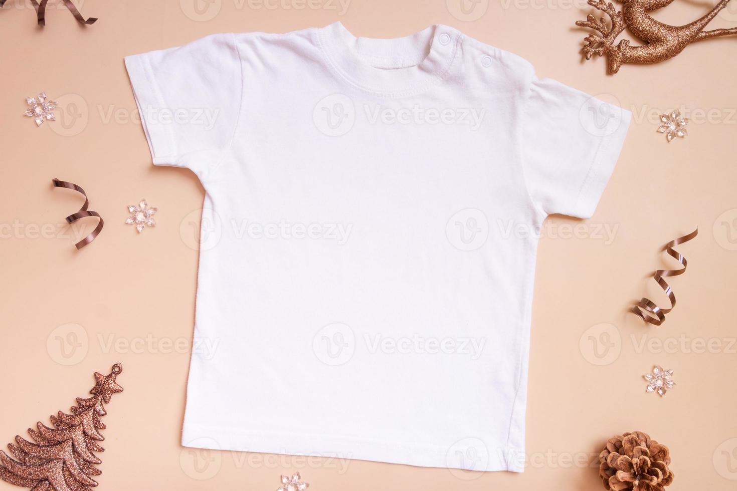 maquete de camiseta de bebê para logotipo, texto ou design em fundo bege com vista superior de decotações de inverno foto