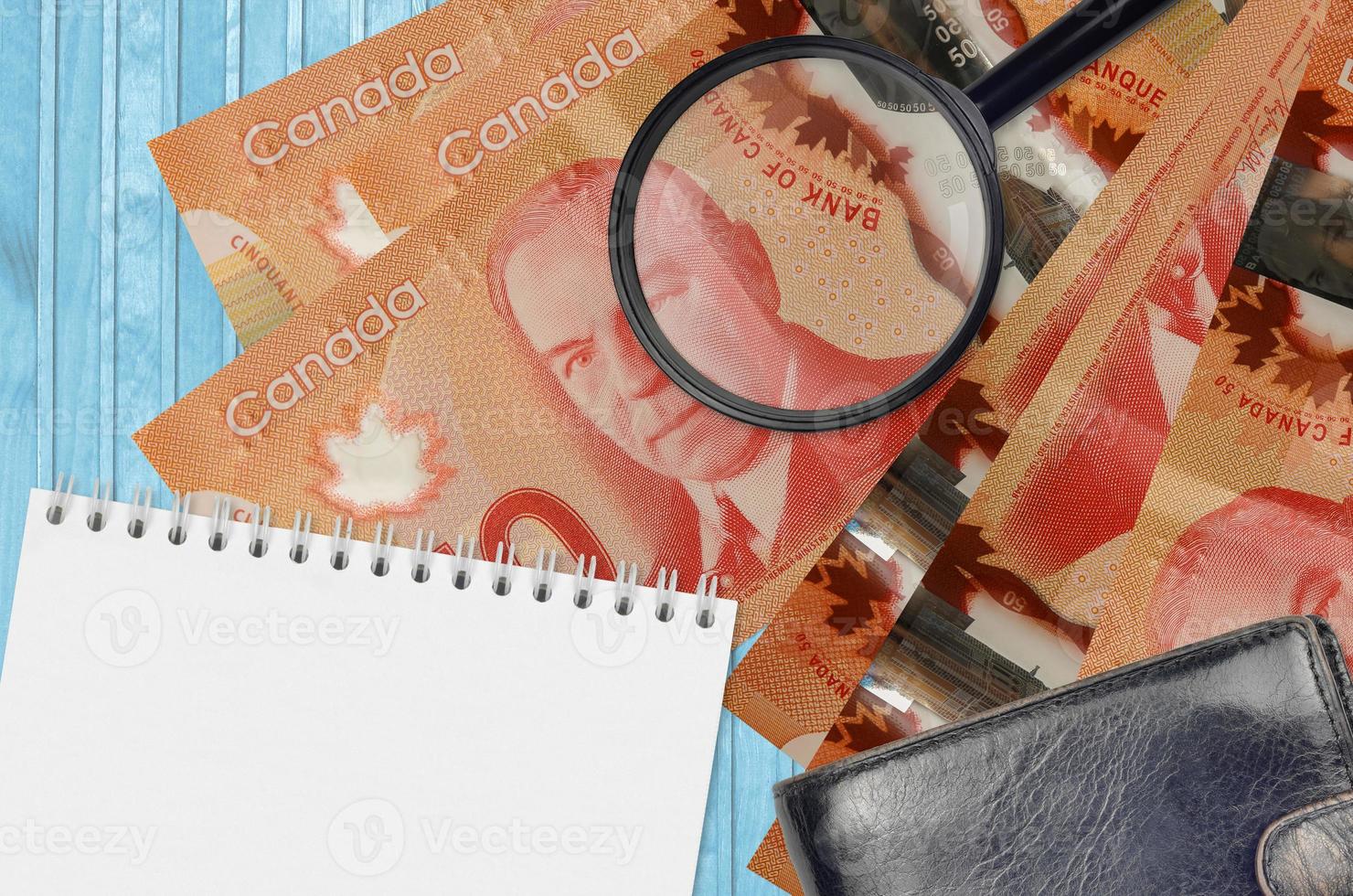Notas de 50 dólares canadenses e lupa com bolsa preta e bloco de notas. conceito de dinheiro falso. procure diferenças nos detalhes das cédulas de dinheiro para detectar falsos foto