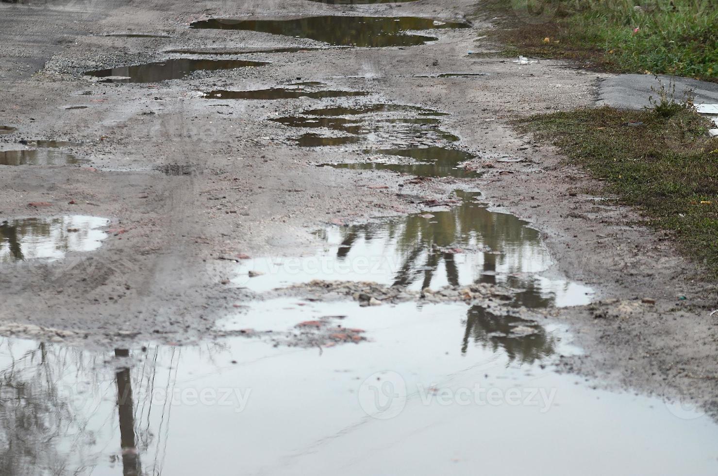 foto de um fragmento de uma estrada destruída com grandes poças em tempo chuvoso