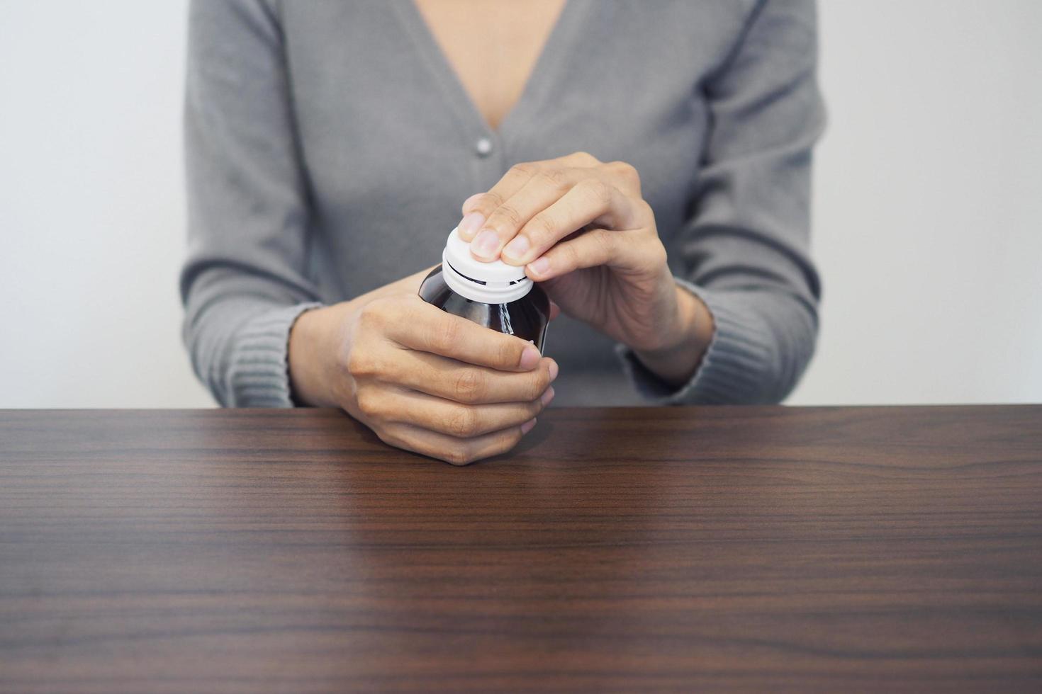 mão feminina jovem segurando um frasco de comprimidos, suplemento dietético feminino ou cápsula tipo vitamina, conceito de cuidados de saúde. foto