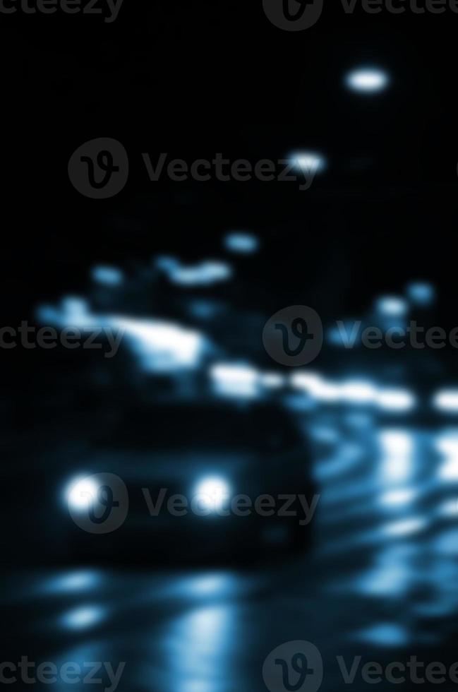 cena noturna turva de tráfego na estrada. imagem desfocada de carros viajando com faróis luminosos. arte bokeh foto