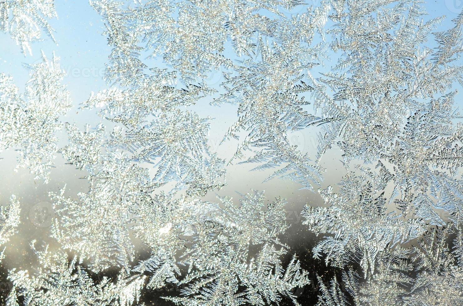 macro de geada de flocos de neve no painel de vidro da janela foto