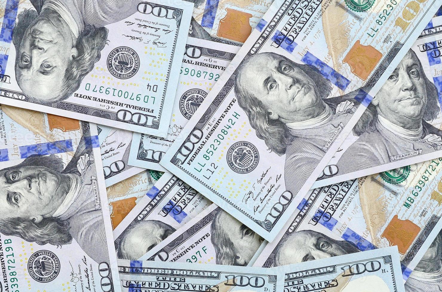 um grande número de notas de dólar americano de um novo design com uma faixa azul no meio. vista do topo foto