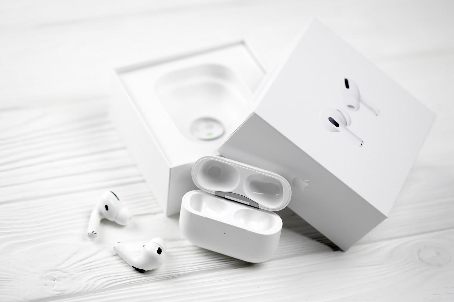 Kharkiv, Ucrânia - 27 de janeiro de 2022 apple airpods pro em um fundo branco. fones de ouvido sem fio com estojo de carregamento e caixa. maçã inc. é uma empresa americana de tecnologia foto