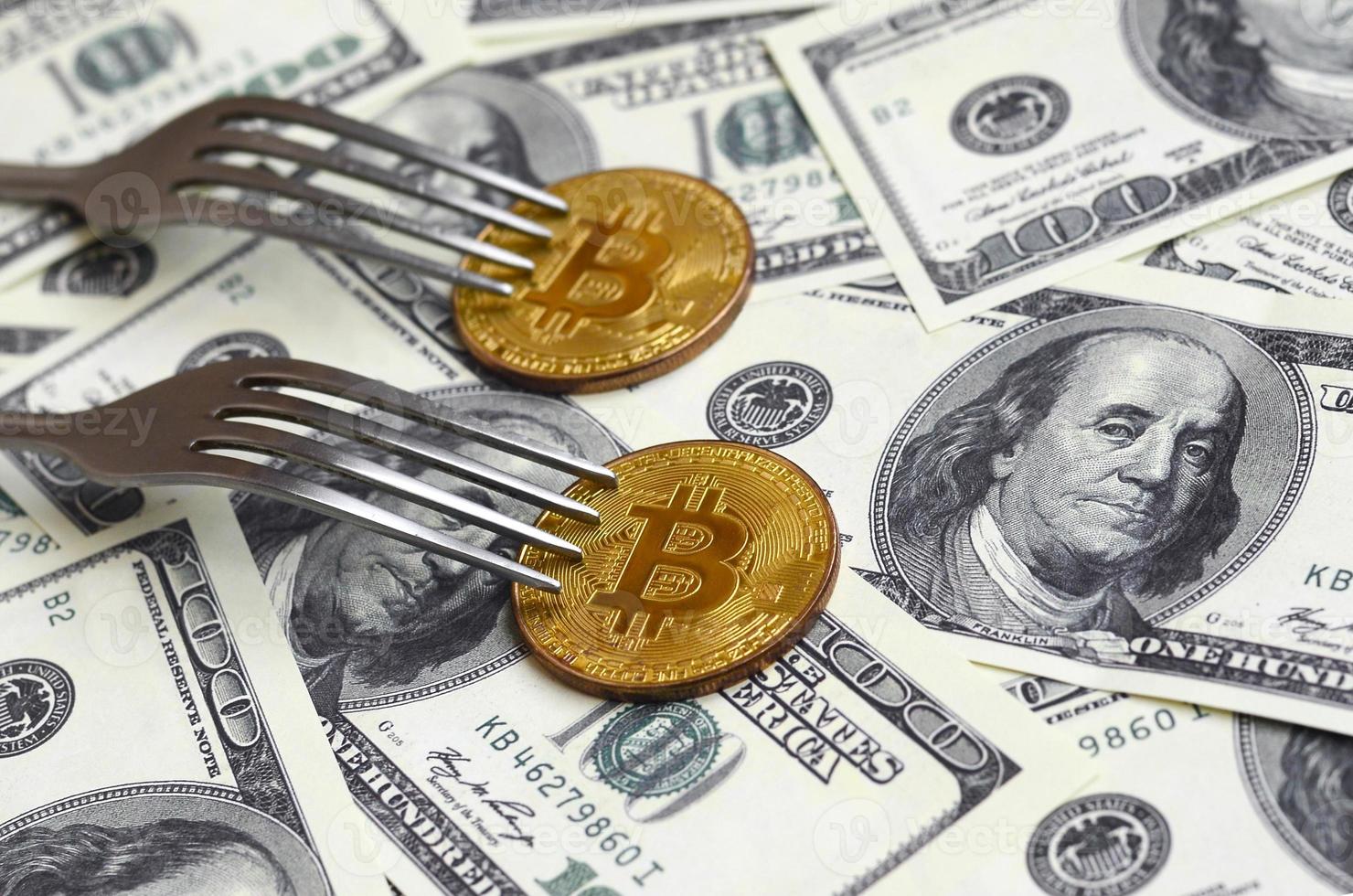 bitcoin recebendo nova mudança de hard fork, moeda de criptomoeda dourada física sob o garfo no fundo de dólares. conceito de crise do sistema de transação blockchain foto