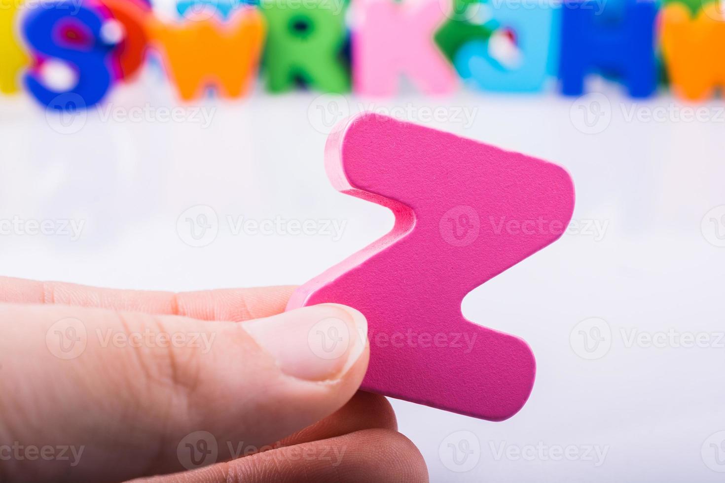 mão segurando a letra cubo z do alfabeto foto