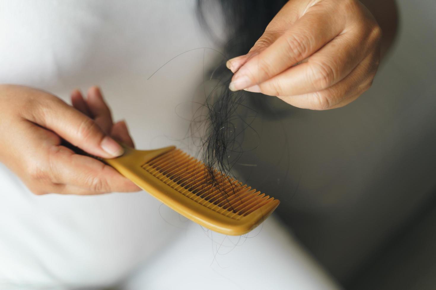 problema de queda de cabelo. mulher asiática com problema de pente e cabelo. perda de cabelo do pente. cuidados com o cabelo e conceitos de beleza. foto