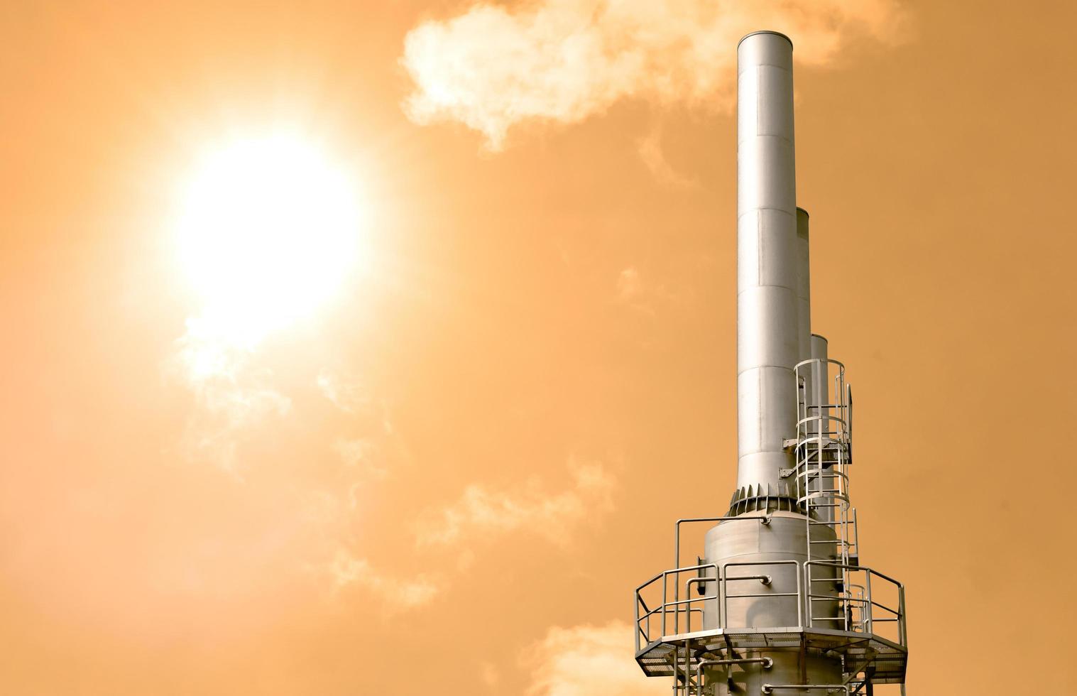 poluição do conceito de aquecimento global na atmosfera da planta industrial chaminé no céu amarelo foto