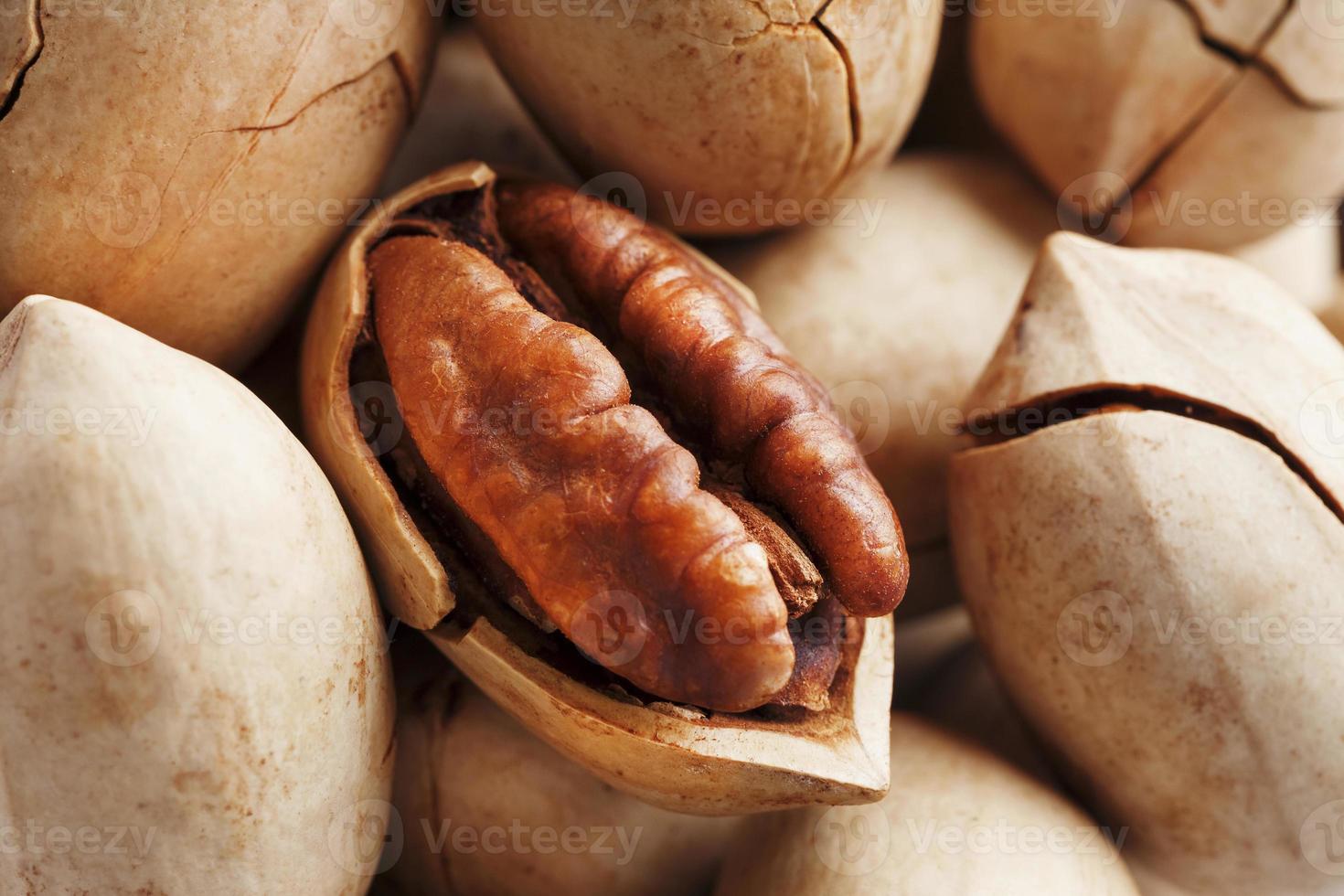 close-up de nozes pecan, macro como pano de fundo em toda a tela. descascado, em uma casca. foto