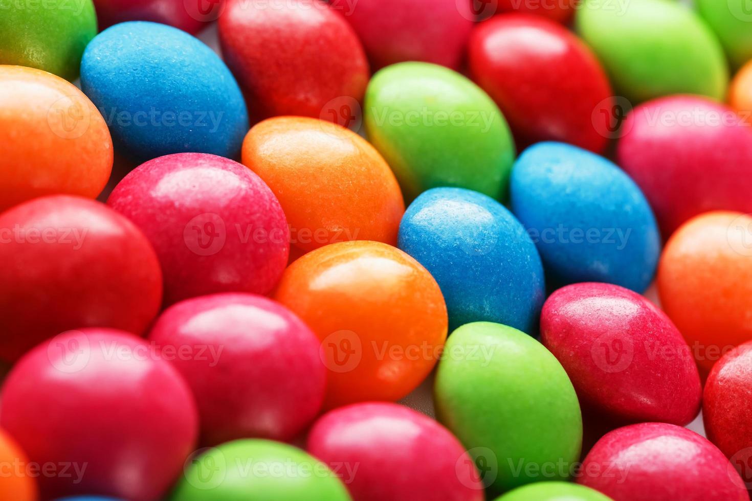 cores do arco-íris de close-up de doces multicoloridos, textura e repetição de drageia foto