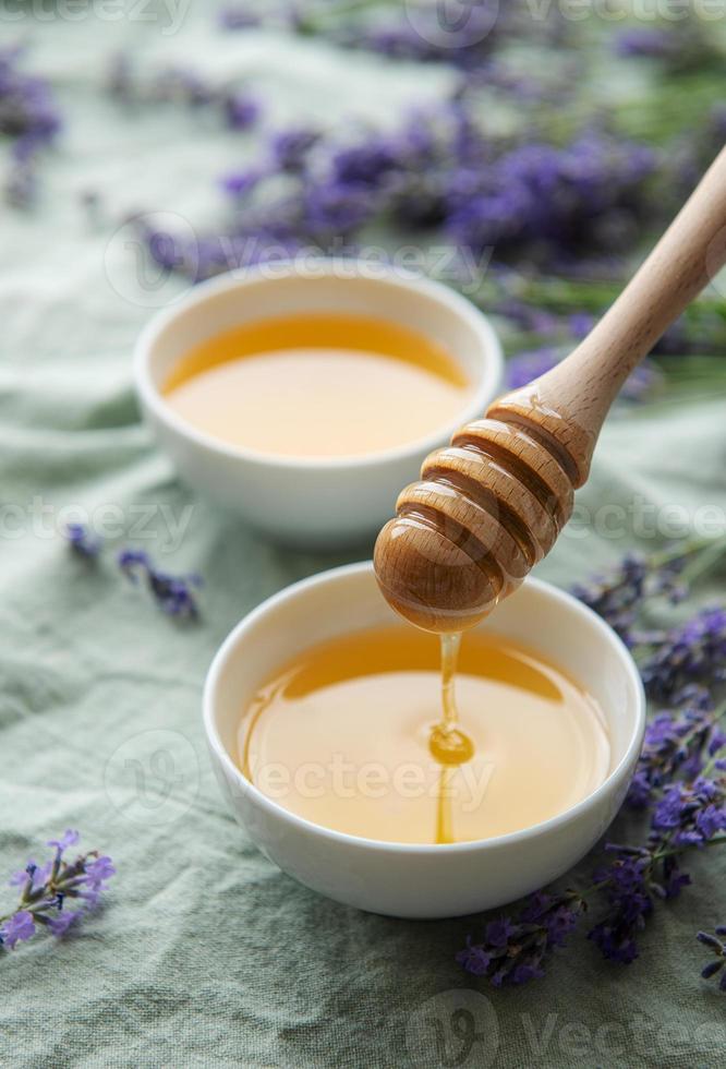 jarra com mel e flores frescas de lavanda foto