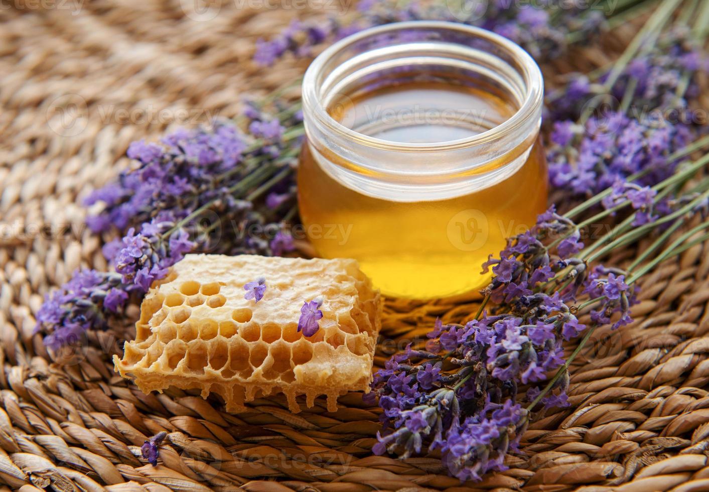 jarra com mel e flores frescas de lavanda foto