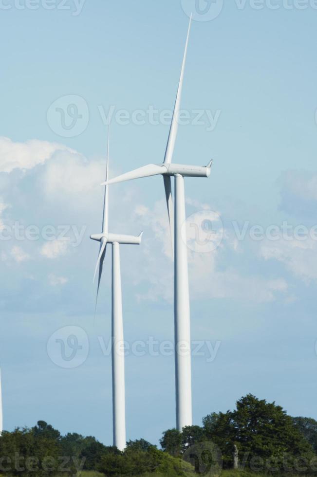 moinhos de vento estão contra um céu azul nublado foto