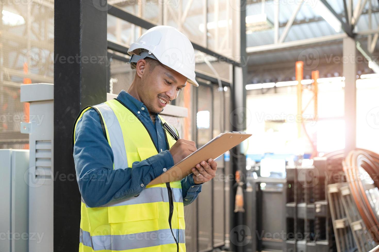 retrato um trabalhador de armazém asiático em um terno de segurança azul segurando a prancheta trabalhando na indústria de loja. centro de distribuição de conceito logístico de importação e exportação. logística e exportação de negócios. foto