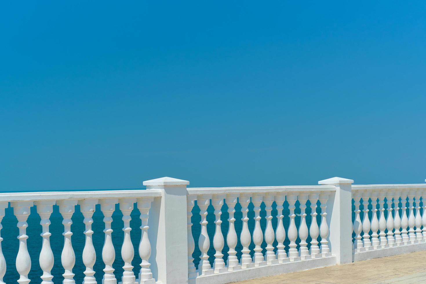 vista de verão com balaustrada branca clássica e terraço vazio com vista para o mar mediterrâneo, ideia de férias. espaço livre para texto foto
