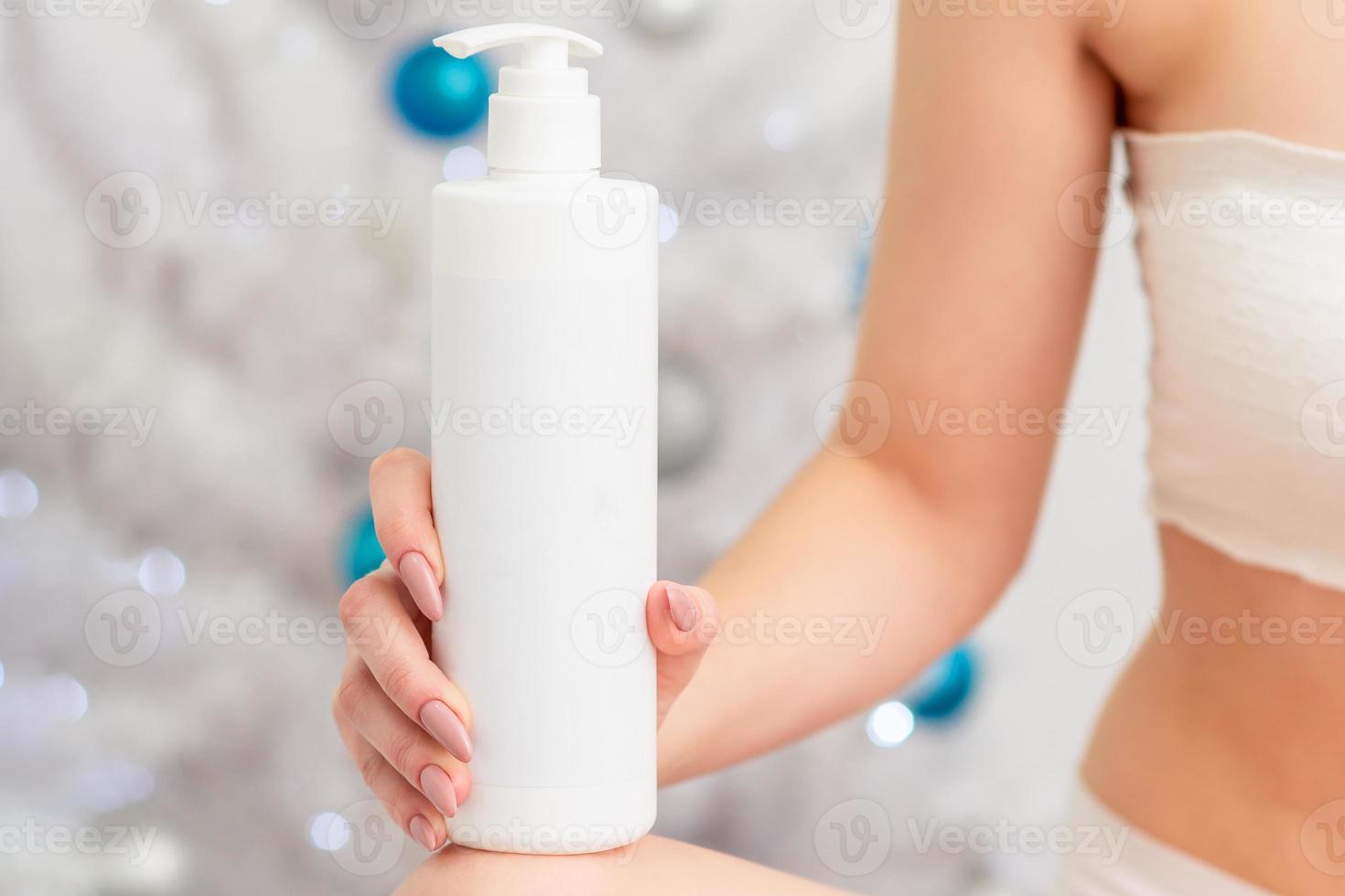 garrafa branca de cosméticos na mão da jovem fêmea foto
