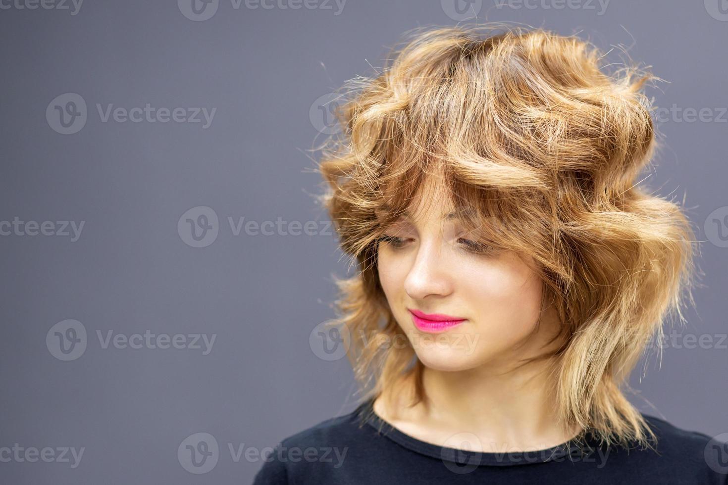 mulher olhando para baixo com penteado longo ondulado ruivo foto