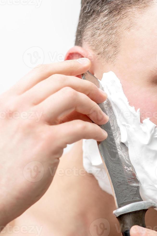 homem fazendo barba com faca foto