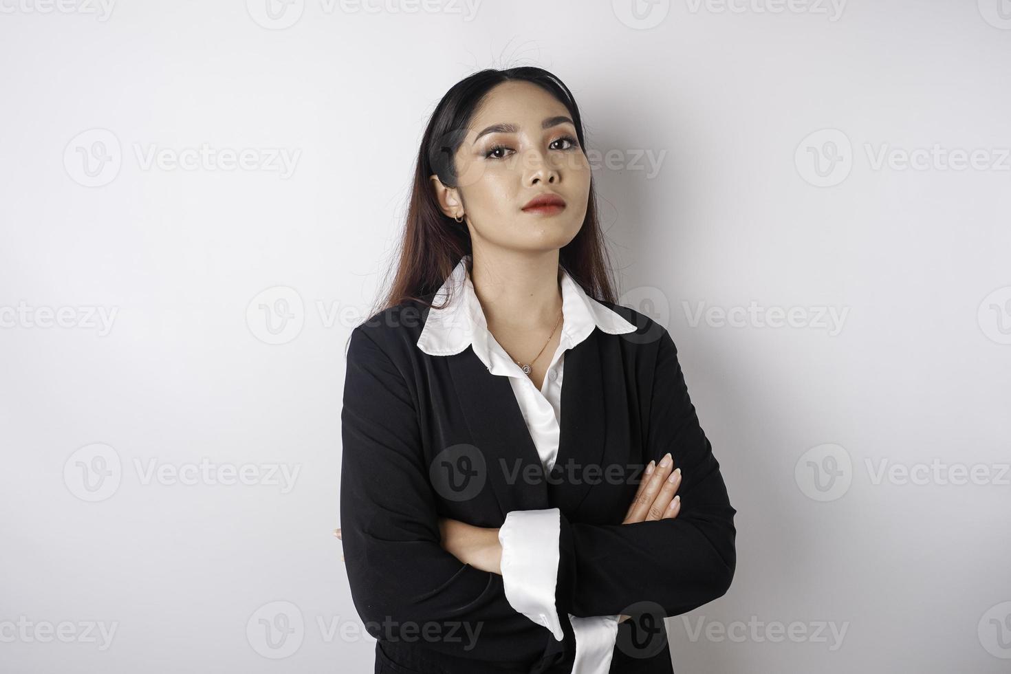 retrato de um chefe de menina asiática sorridente confiante vestindo terno preto em pé com os braços cruzados e olhando para a câmera isolada sobre fundo branco foto